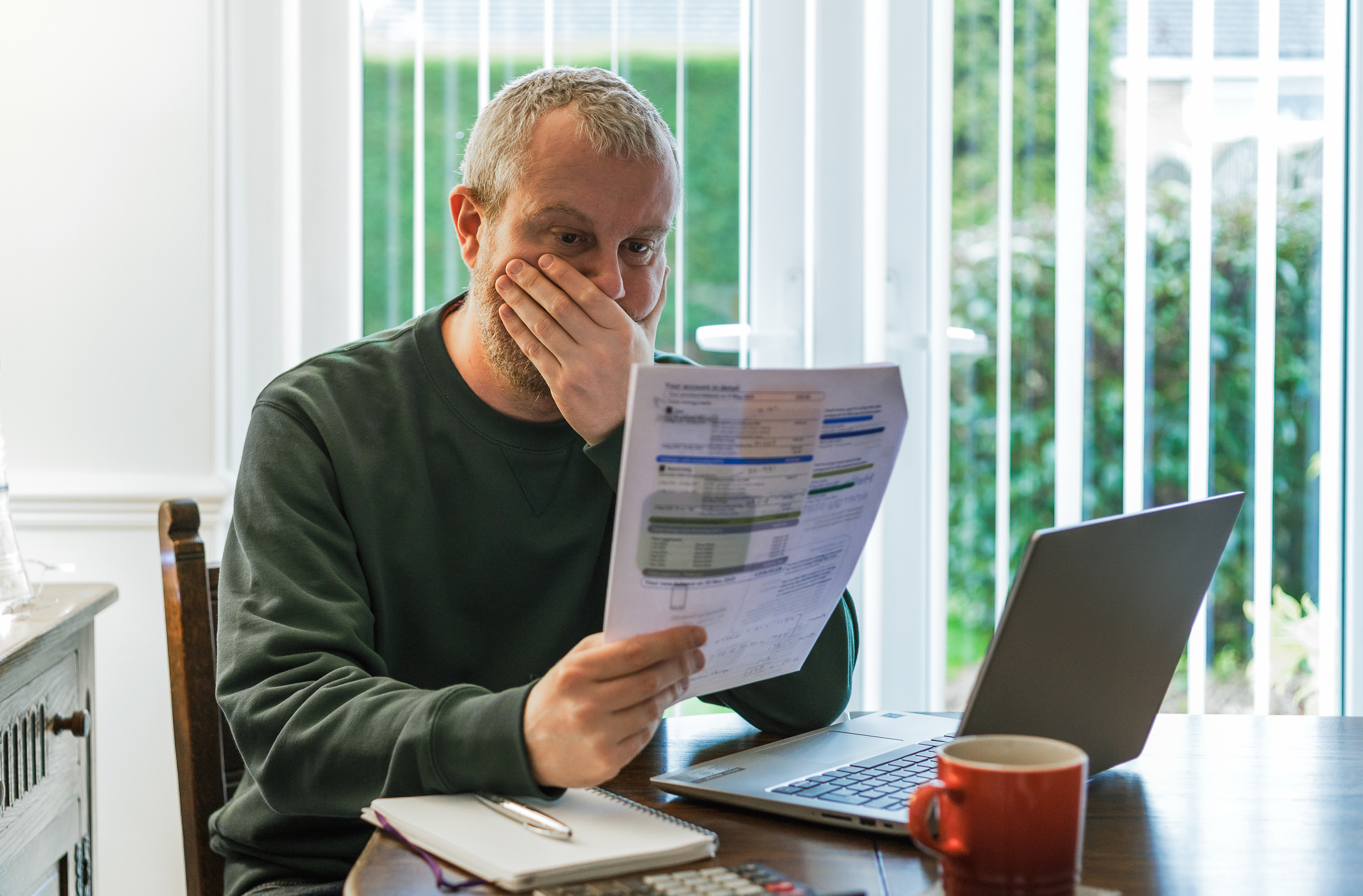 Man looking at a house price valuation in shock