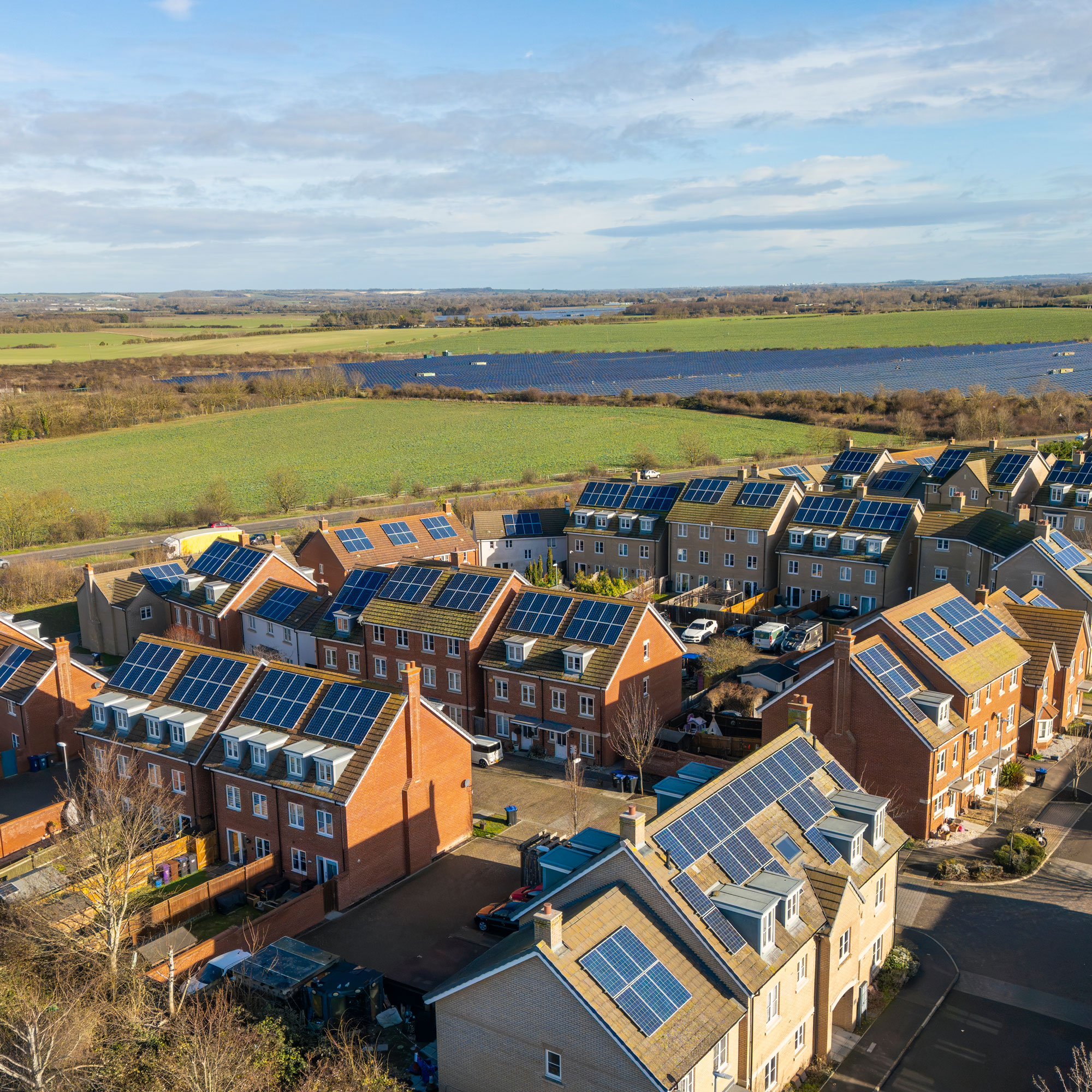 Solar panel on the roofs of an estate in the UK, next to fields