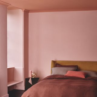 pink and coral painted bedroom with painted ceiling with ochre headboard and terracotta bedlinen