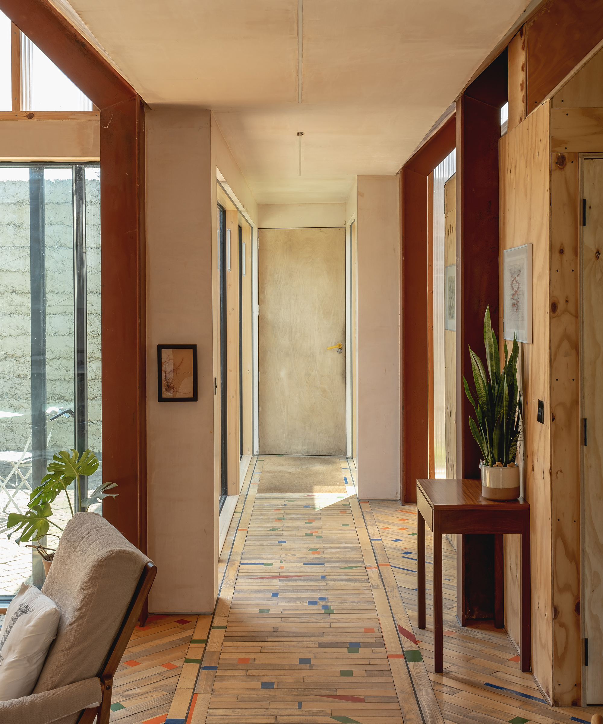 A corridor with thin floorboards laid in an interesting pattern.