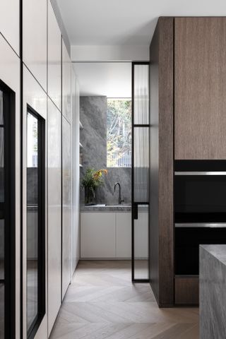 Kitchen looking through to utility at minimalist Armadale Residence in Australia