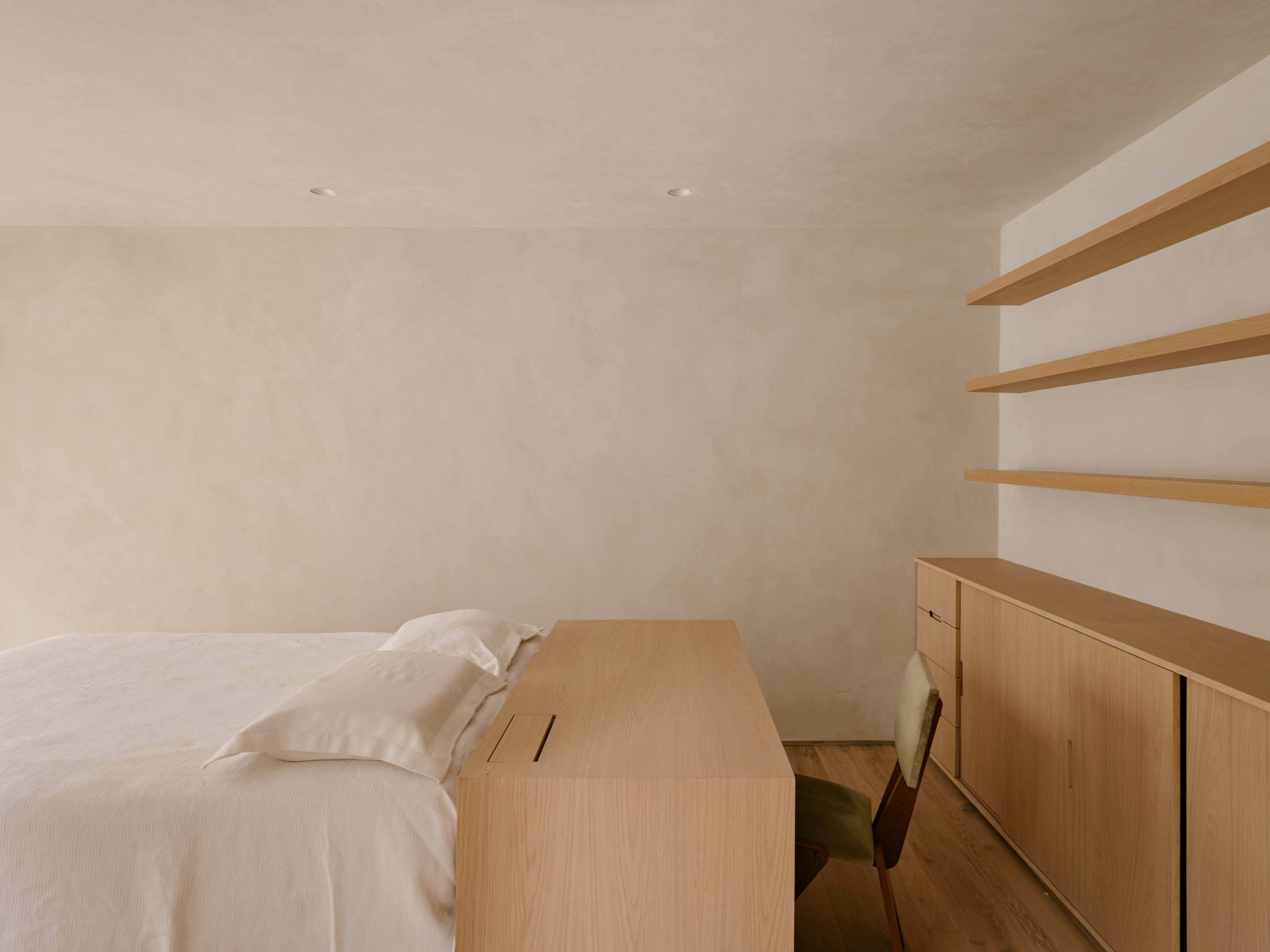 One of the minimally detailed bedrooms with custom furniture and cabinetry