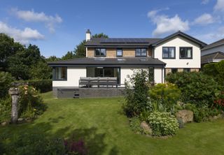 detached house extension with solar panels and garden