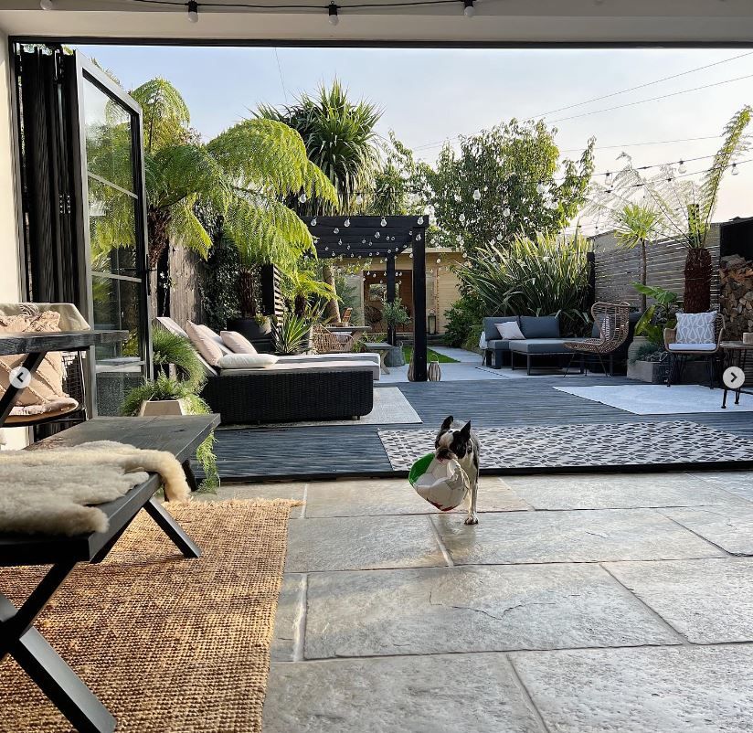 Kitchen area with the bifold doors opened up to reveal a stunning garden
