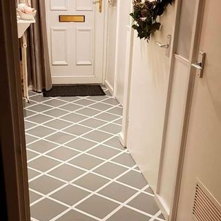 hallway with grey tile painted flooring and white door