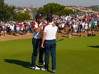 Viktor Hovland and Edoardo Molinari celebrating together on the green at the 2023 Ryder Cup
