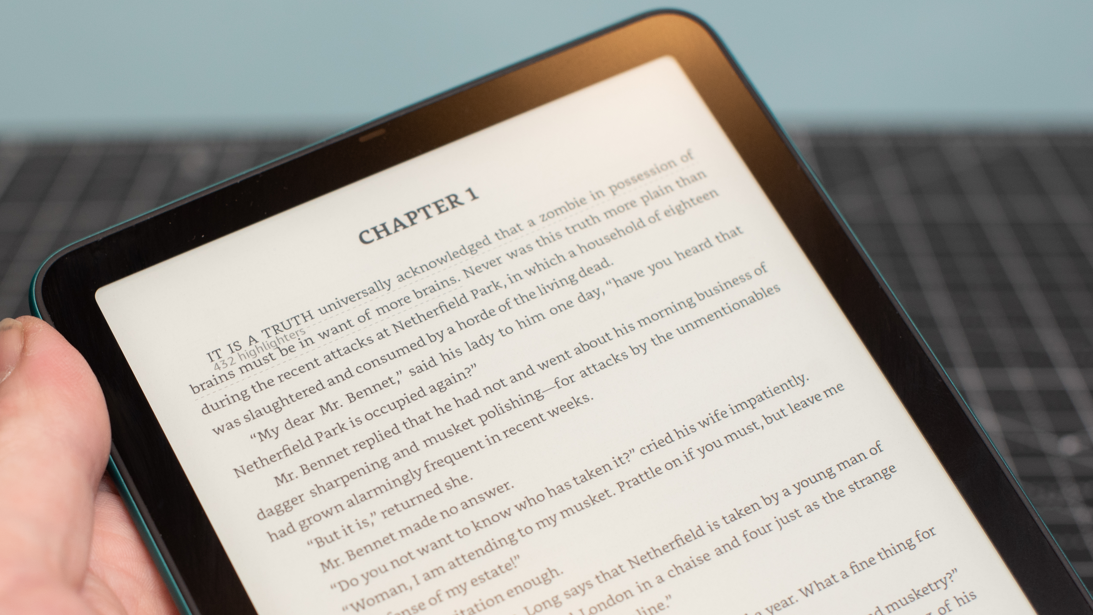 Kindle Paperwhite showing text from the book Pride and Prejudice and Zombies on the top of the screen