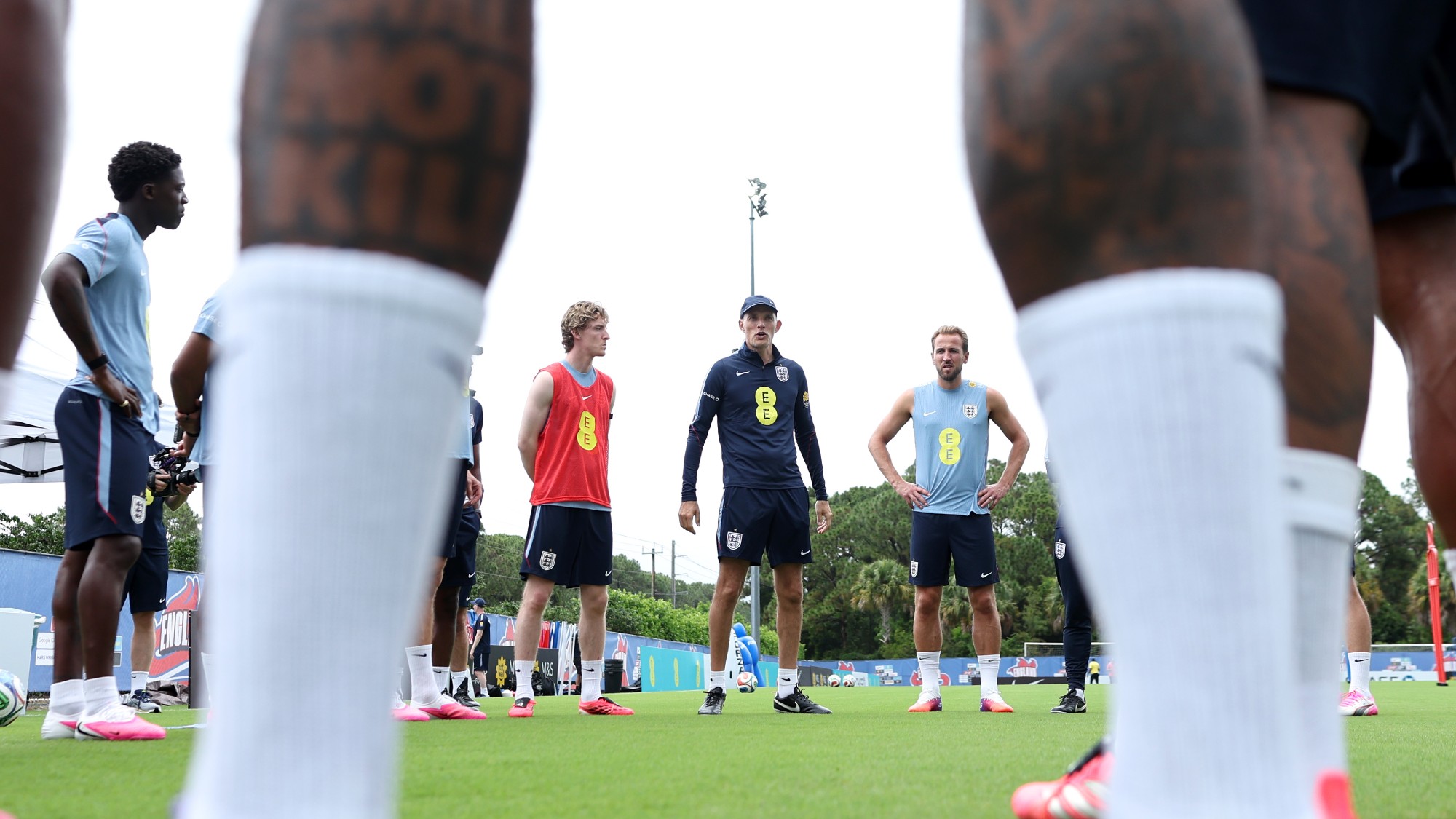 Thomas Tuchel speaks to his players including Anthony Gordon, Harry Kane and Kobbie Mainoo prior to a training session in West Palm Beach, Florida