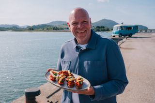 Tom holds out a dish in Tom Kerridge Cooks Spain