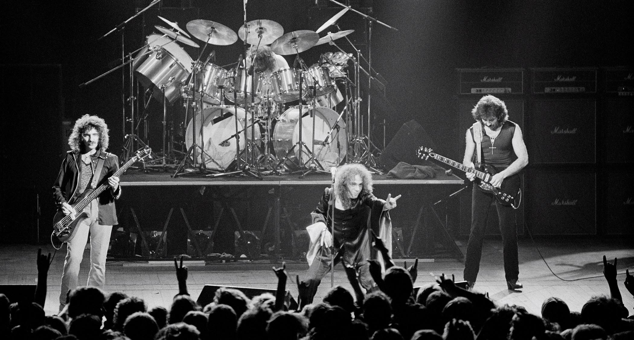 Black Sabbath onstage in 1980 with Ronnie James Dio fronting the band, and throwing the horns at the audience.