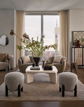 Two stools sit before a white coffee table and matching armchairs