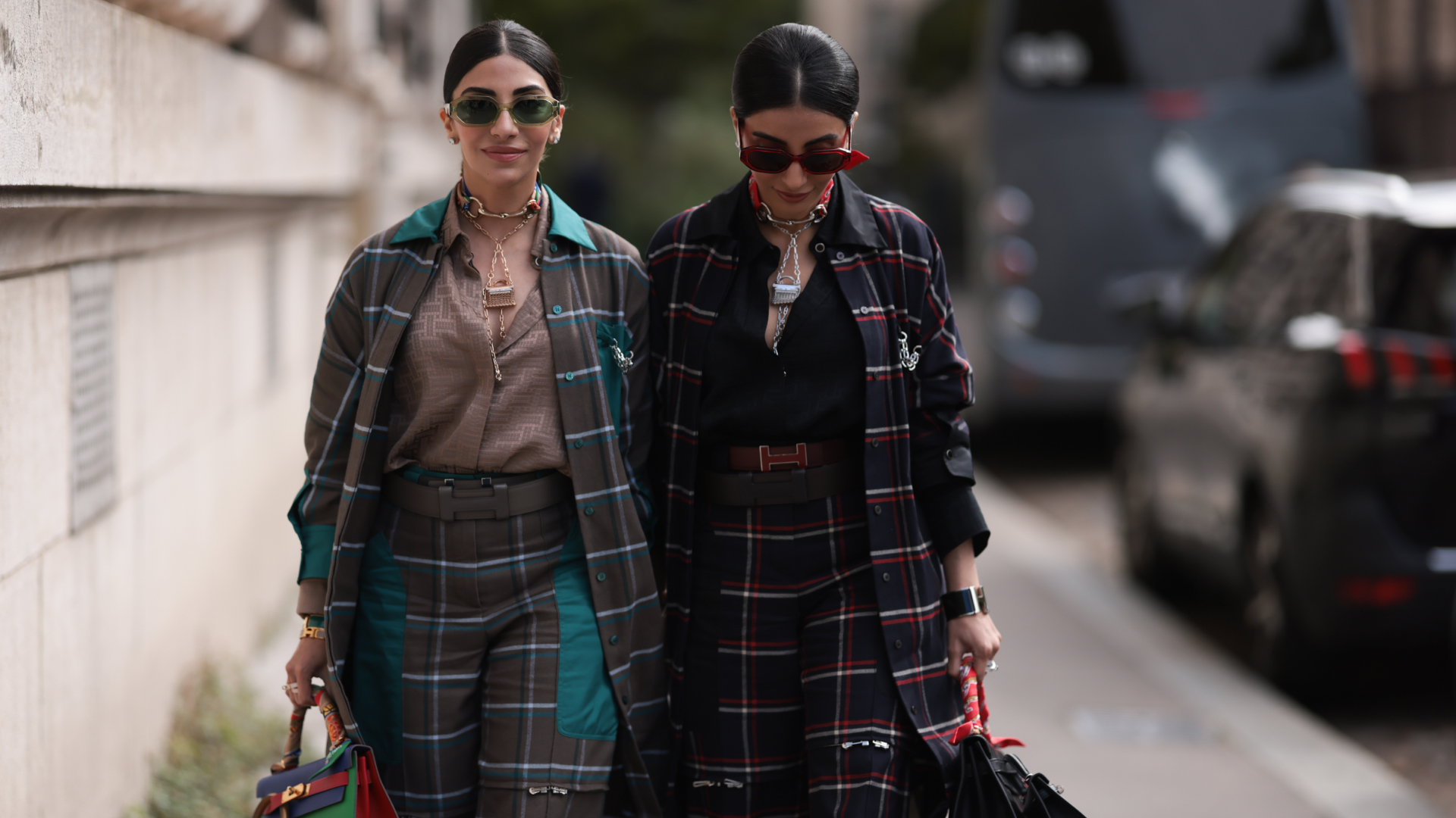 Jyoti Babani (left) and Snehal Babani (right) at fashion week wearing checked suits and sunglasses 