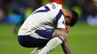 Tottenham captain Cristian Romero bowing his head in dejection