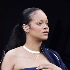 Rihanna wearing a striped top, khaki skirt, and sneakers