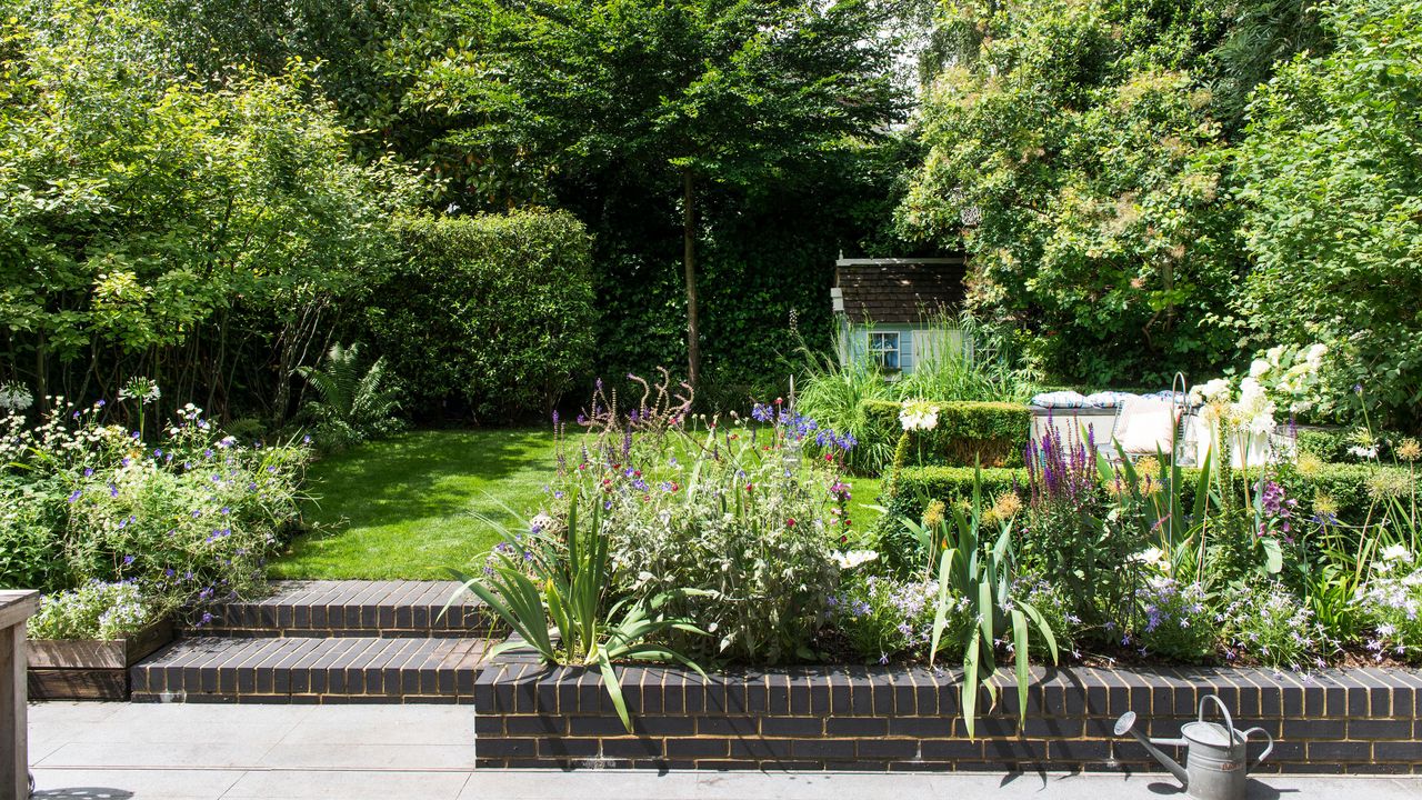 back garden with landscaping, steps and grass lawn