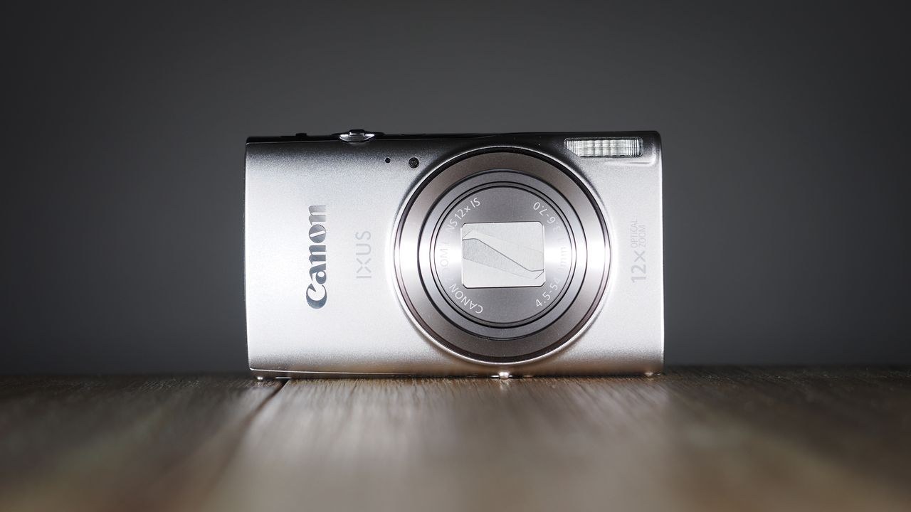 Canon Ixus 285 HS A on a wooden surface against a dark background