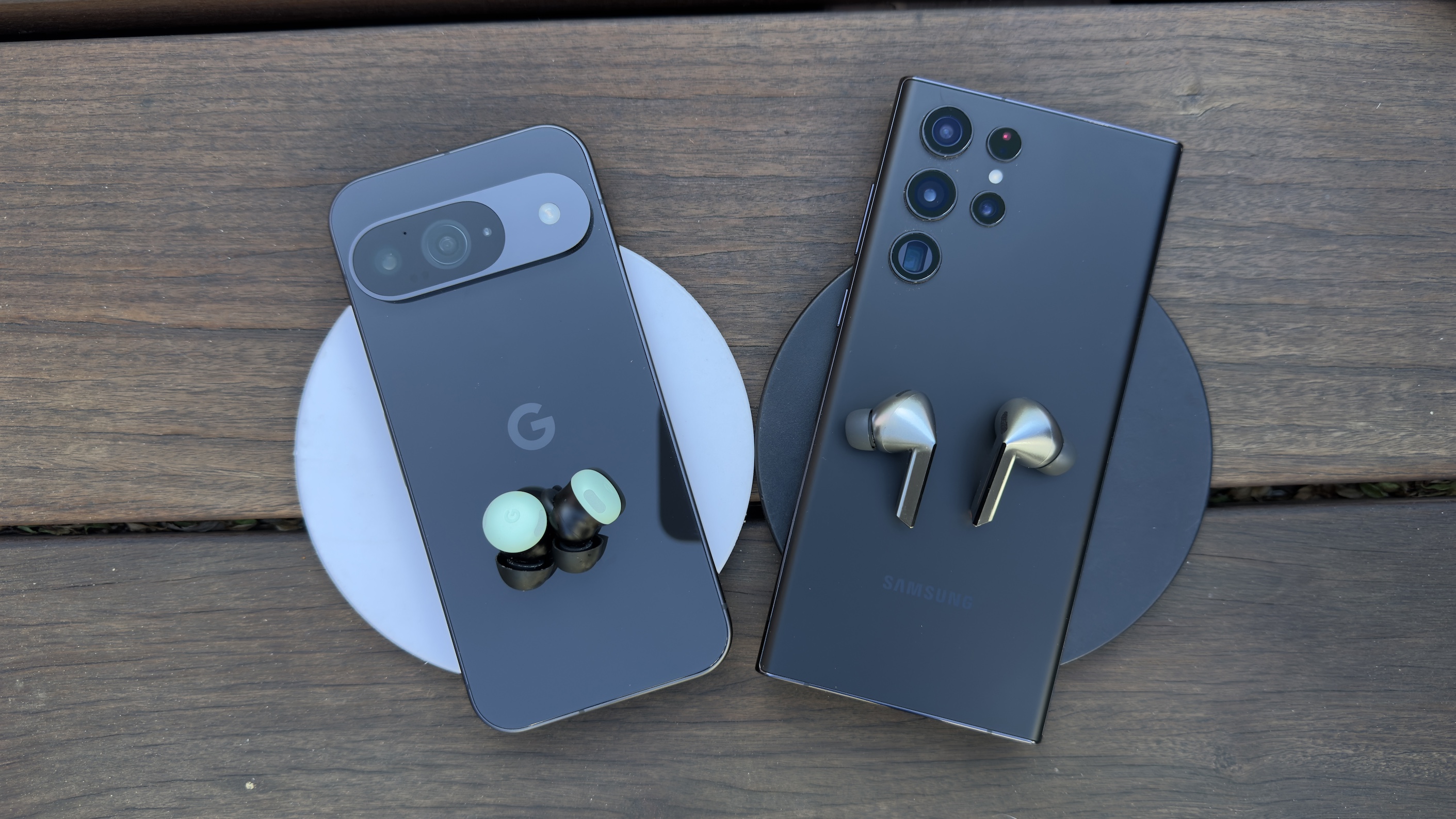 Image showing both pairs of earbuds on top of their respective phones