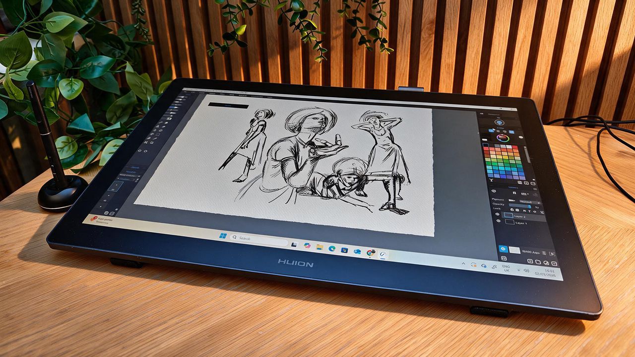 A black drawing tablet on a wooden desk
