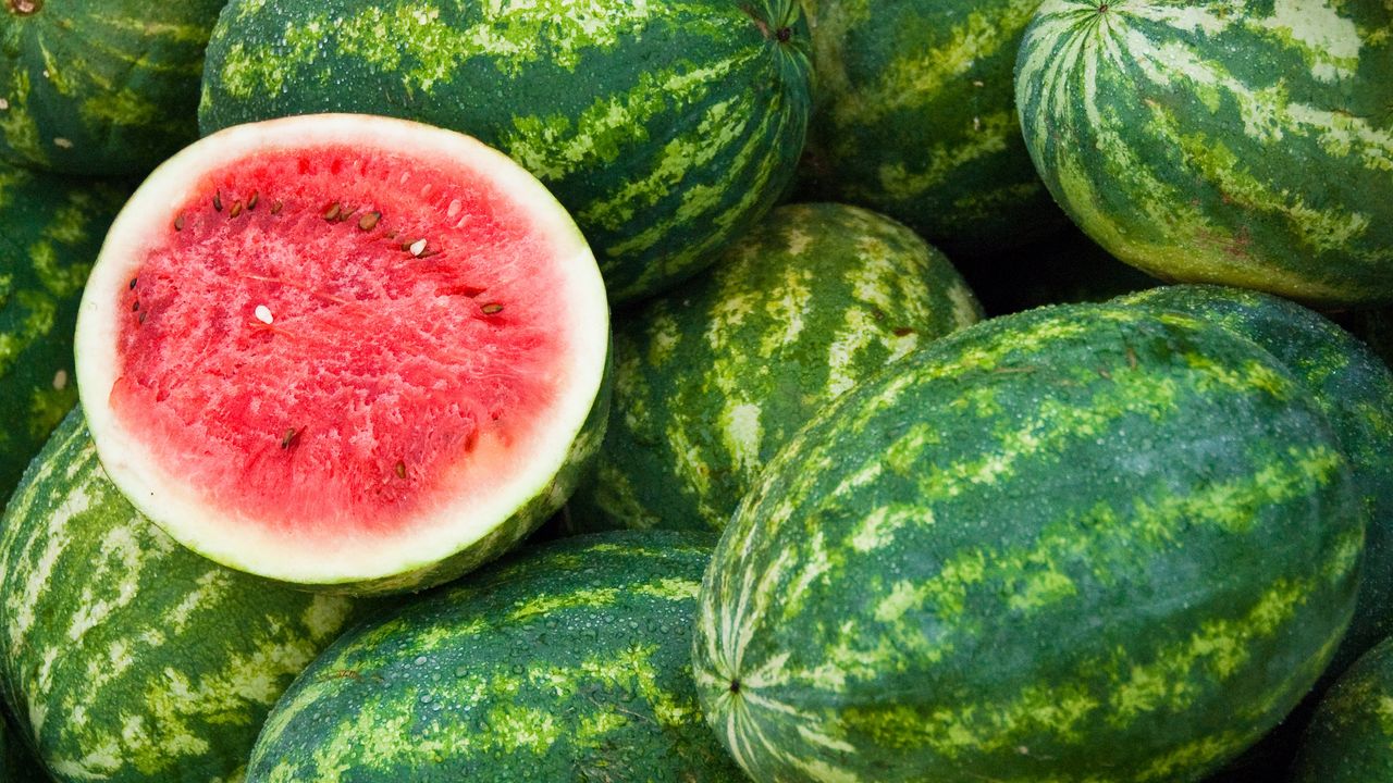 Pile of watermelons with one cut in half for viewing