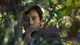 Lee Byung-hun in a tree in No Other Choice.