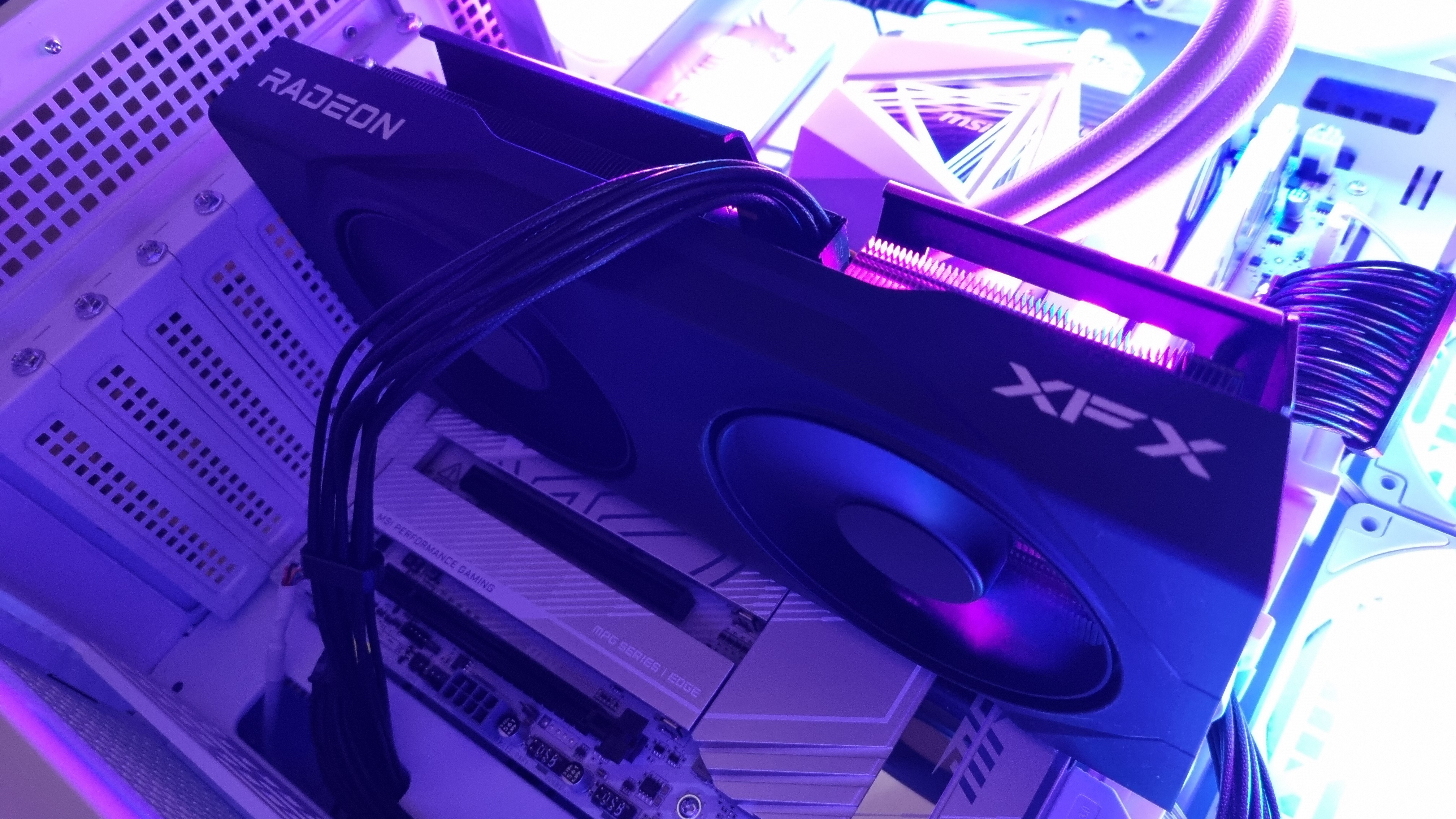 The XFX Swift AMD Radeon RX 9060 XT in a PC Gamer benchmarking PC, lit up in RGB