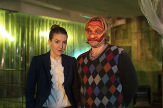 Gemma Whelan as Columbina and Kevin Bishop in a glum-looking red mask as Arlo