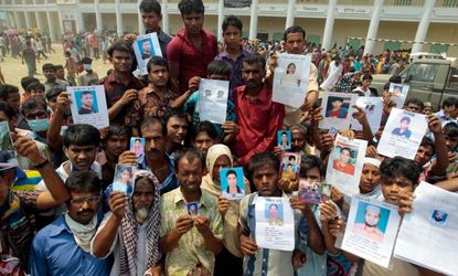 A Bangladeshi display pictures of missing relatives outside the site of the building collapse.