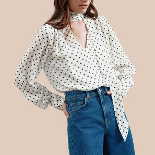 Flat lay image of woman wearing polka dot blouse