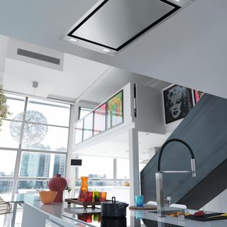 white kitchen with stainless steel cooker hood in ceiling