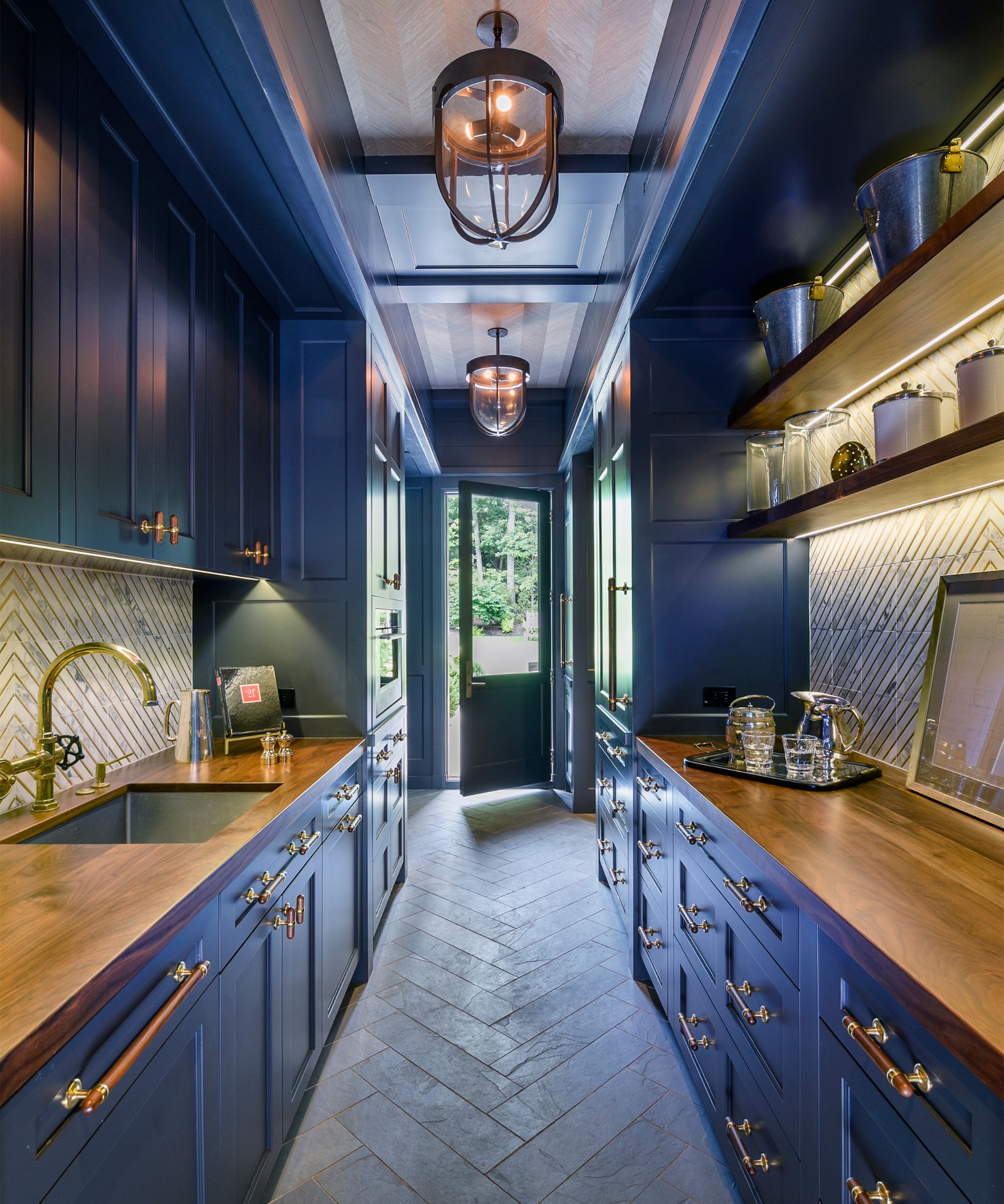 Larder with blue cabinets and wood countertop, large pendant lights and tiled floor