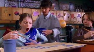 Teisha Kim pours paint on Michelle Trachtenberg as Gregory Smith watches in Harriet the Spy.