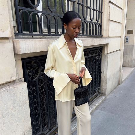 a woman wearing a creme satin top and pants