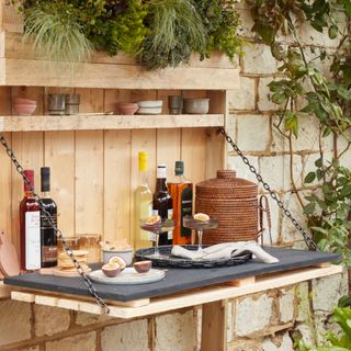 outdoor wall mounted bar with drink prep area, small shelf, made from a pallet