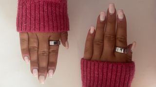 Woman's hands with pink wool sleeve wearing the Oura Ring 3 on one index finger and the Oura Ring 4 on the other.