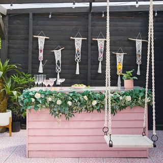 Pink outdoor bar with macrame bottle holders and swing