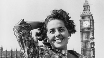 black and white photo of young Boothroyd with her hand in her hair in front of Big Ben