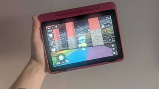 Hand holding Fire HD 8 Kids Pro tablet with Dandy's World gameplay on screen.