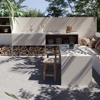 outdoor kitchen with storage, sink, bench seating, table, stools