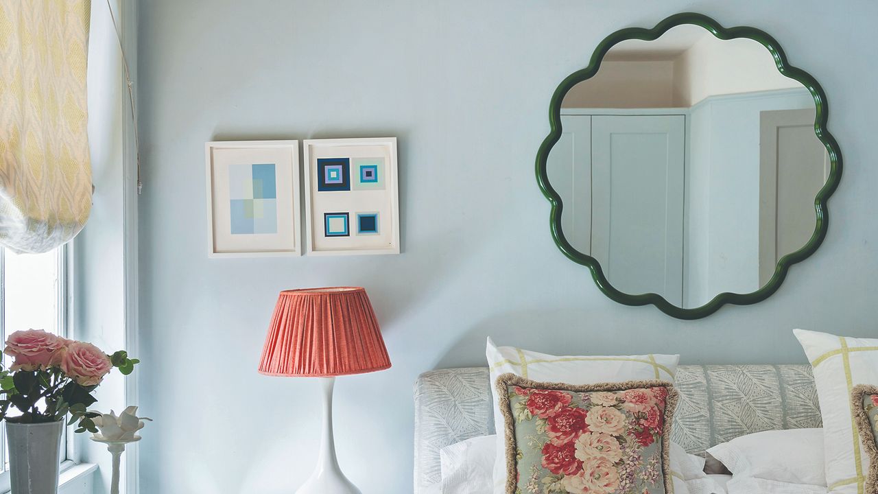 A bedroom with a wavy mirror above the bed