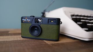 The Camp Snap camera, in forest green, sits on a table