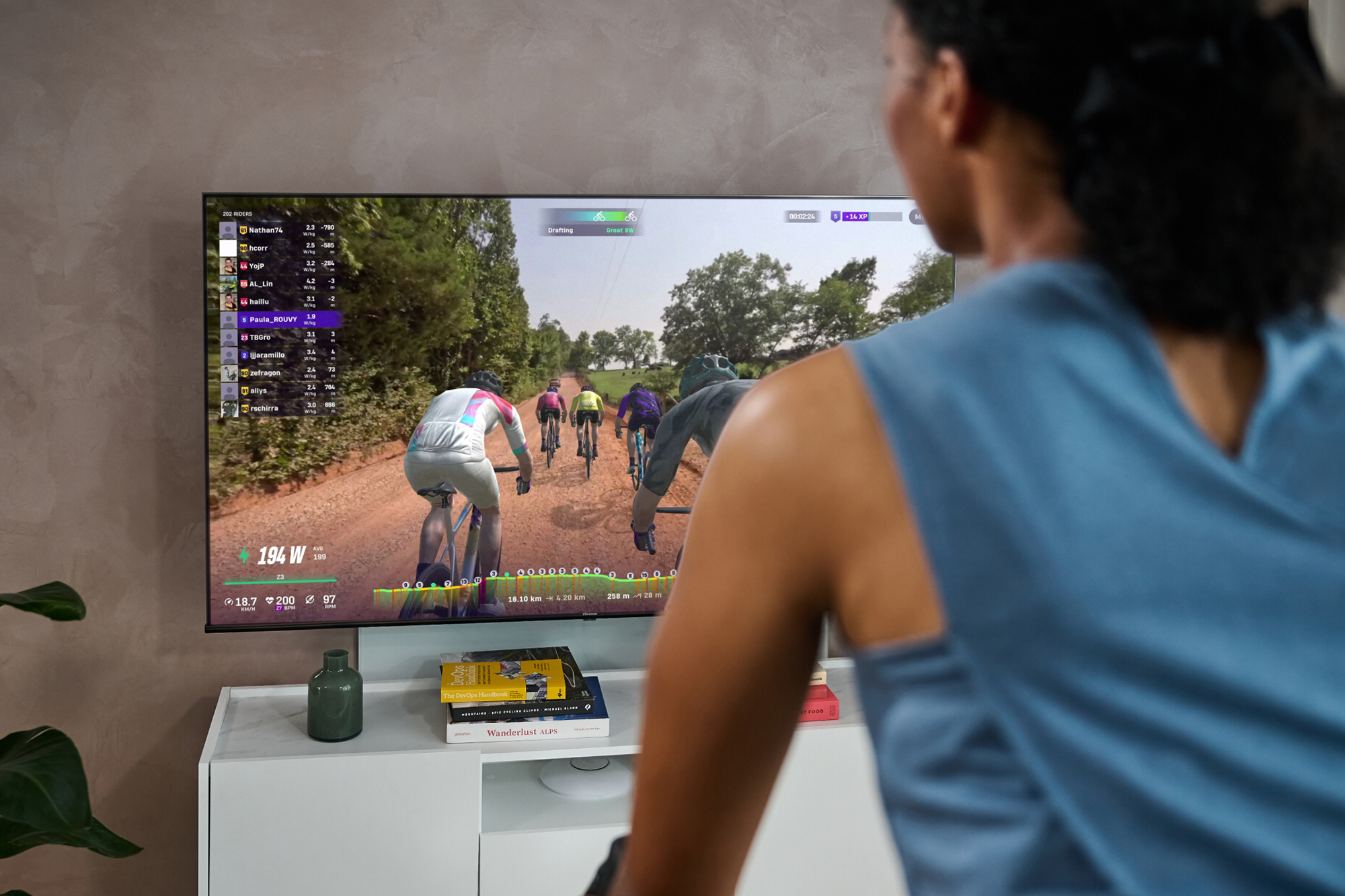 Female rider using Rouvy on TV screen/monitor