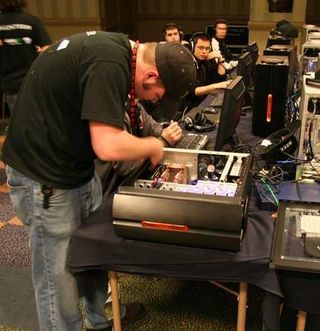 A CPL volunteer tries to make a few repairs to one of the gaming PCs used for the Counter-Strike tournament.