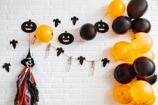 A wall decorated with Halloween bunting and Halloween balloon art.