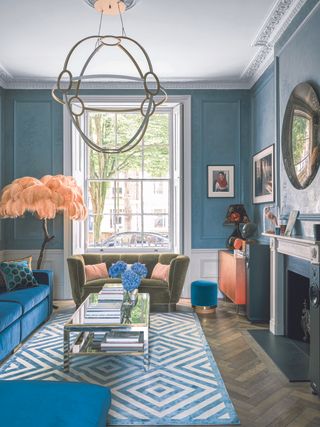 A living room painted blue with a large sash window