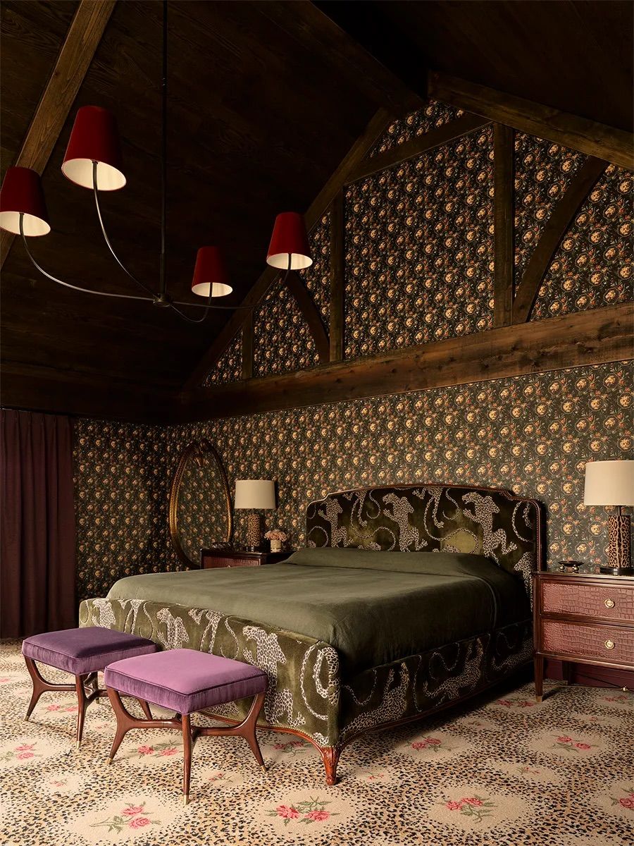 A contemporary bedroom featuring leopard print, floral prints and a combination of materials including leather, velvet, and wood