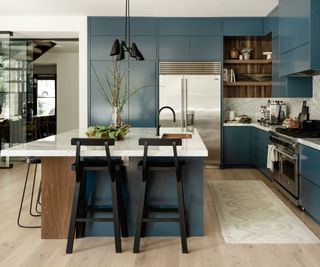 kitchen with blue cabinetry, marble backsplash and with wooden floors
