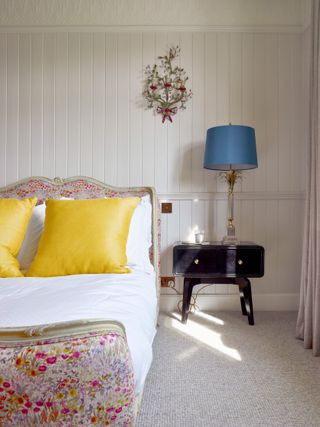 White panelled bedroom with patterned bed frame