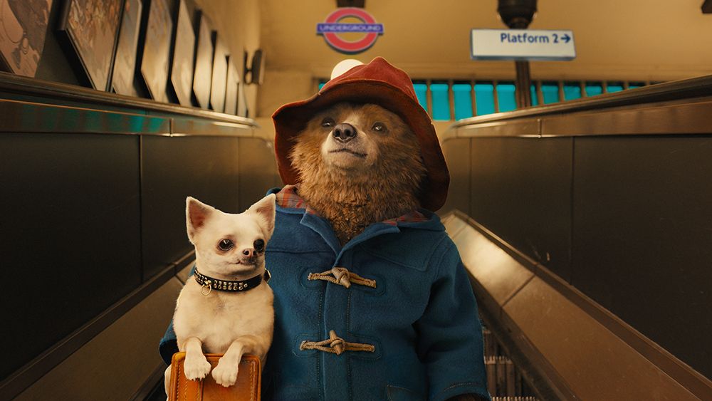 A still from Paddington, one of the January&#039;s new Max movies, showing Paddington on a London Underground escalator wearing his classic blue coat and red hat.