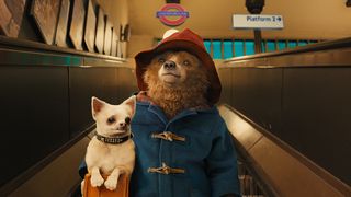 A still from the movie Paddington, one of May's new Hulu movies, showing the bear on a London Underground escalator wearing his classic blue coat and red hat.