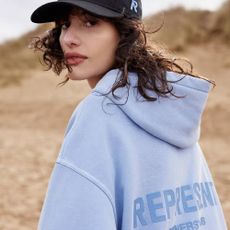 A model wearing a light blue hoodie from Coggles.